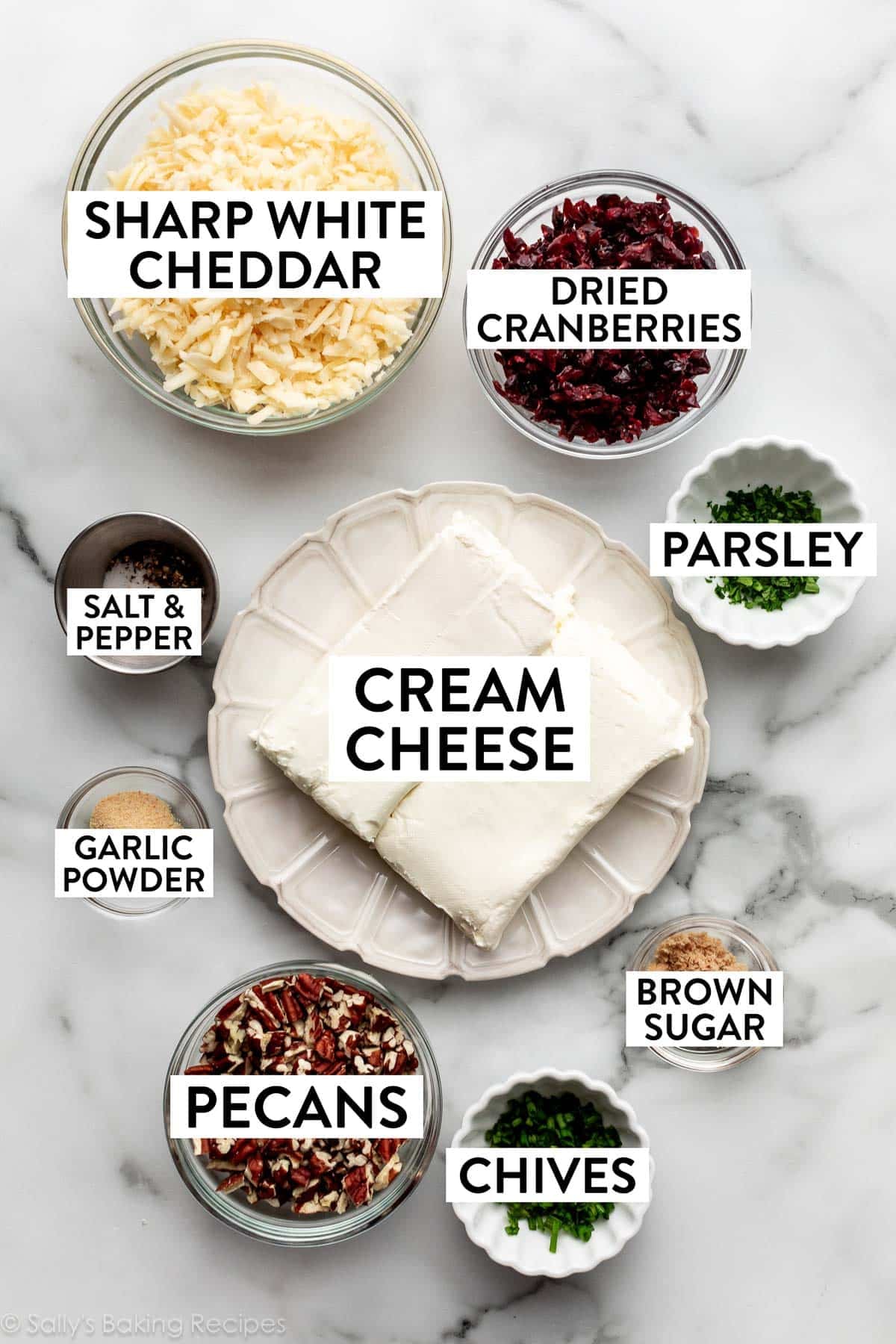 ingredients on counter including cranberries, chives, parsley, salt, pepper, garlic powder, and pecans.