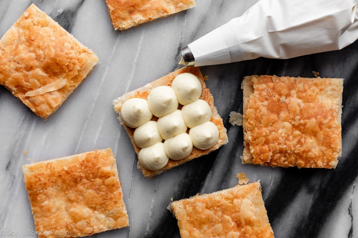 dollops of creme legere on puff pastry squares.