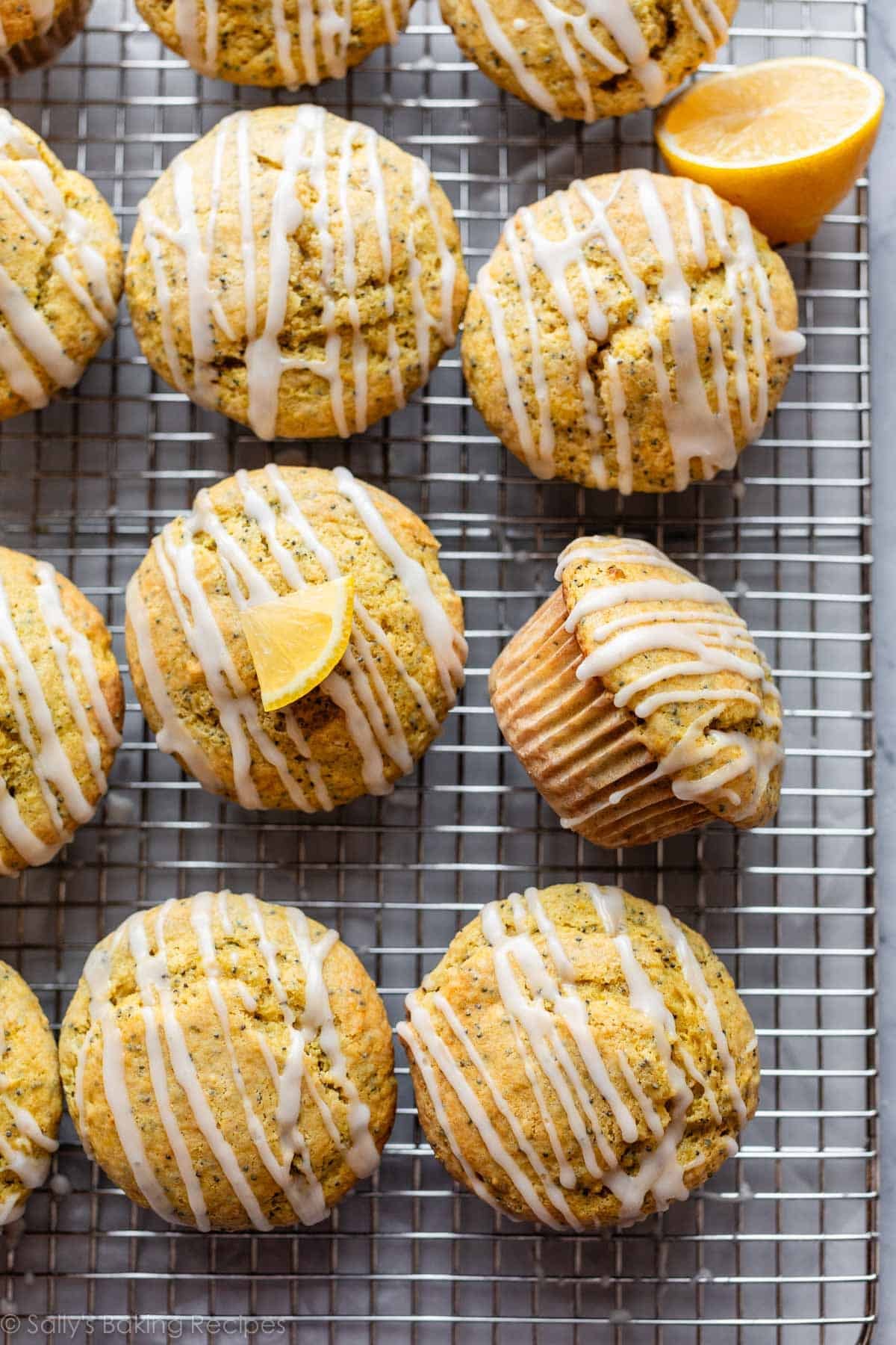 lemon poppy seed muffin with icing on top turned on its side on cooling rack.