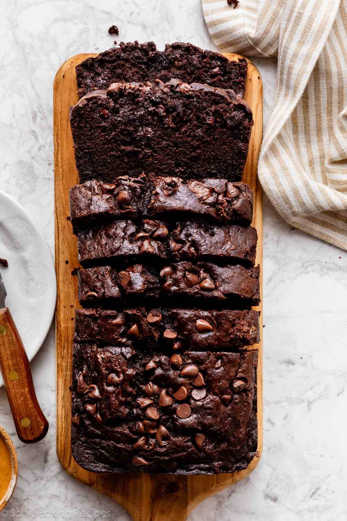 sliced loaf of chocolate banana bread on loaf shaped cutting board.