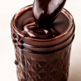 close-up of hot fudge sauce in glass jar.