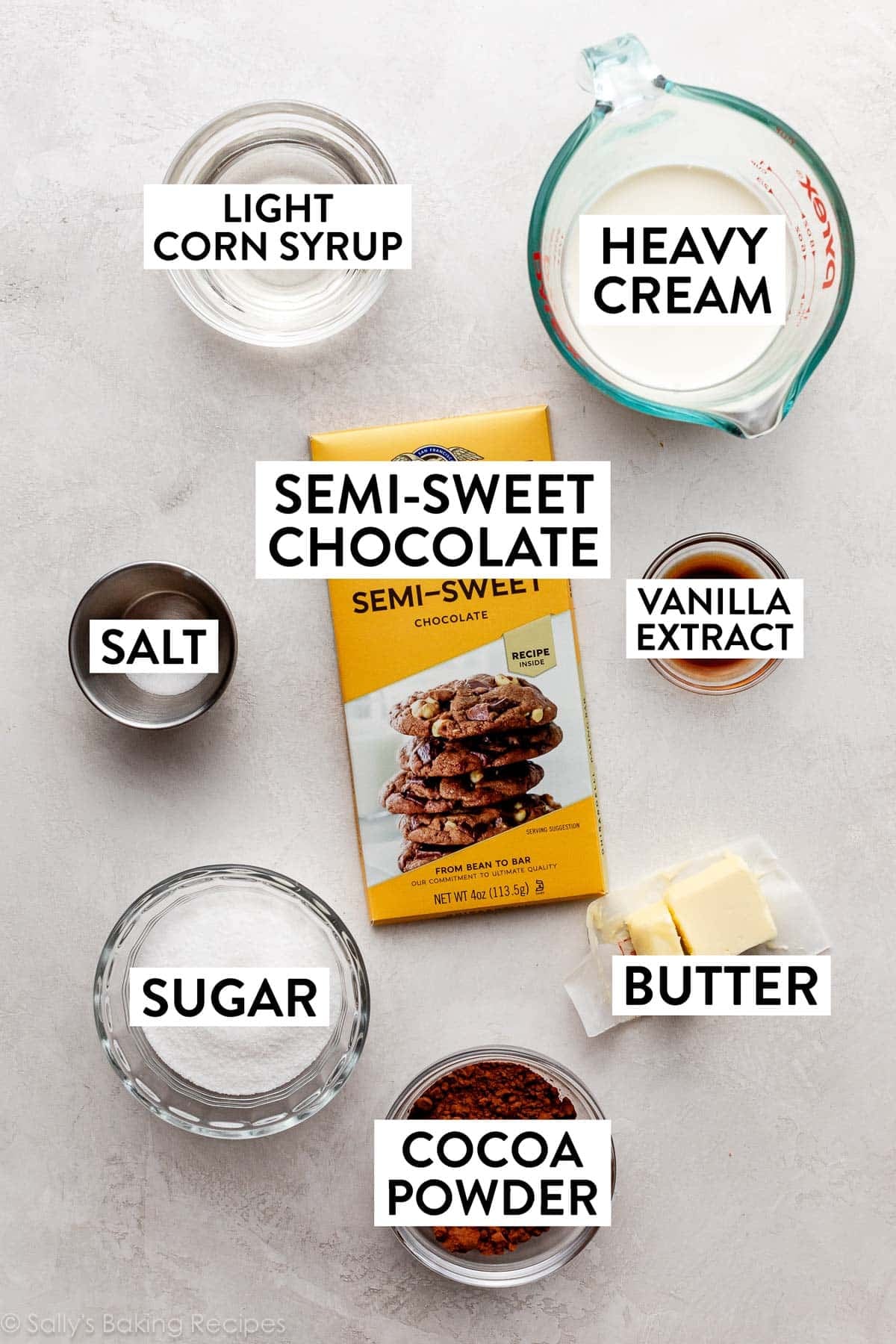 ingredients on counter including heavy cream, bar of chocolate, sugar, cocoa powder, butter, vanilla, salt, and corn syrup.