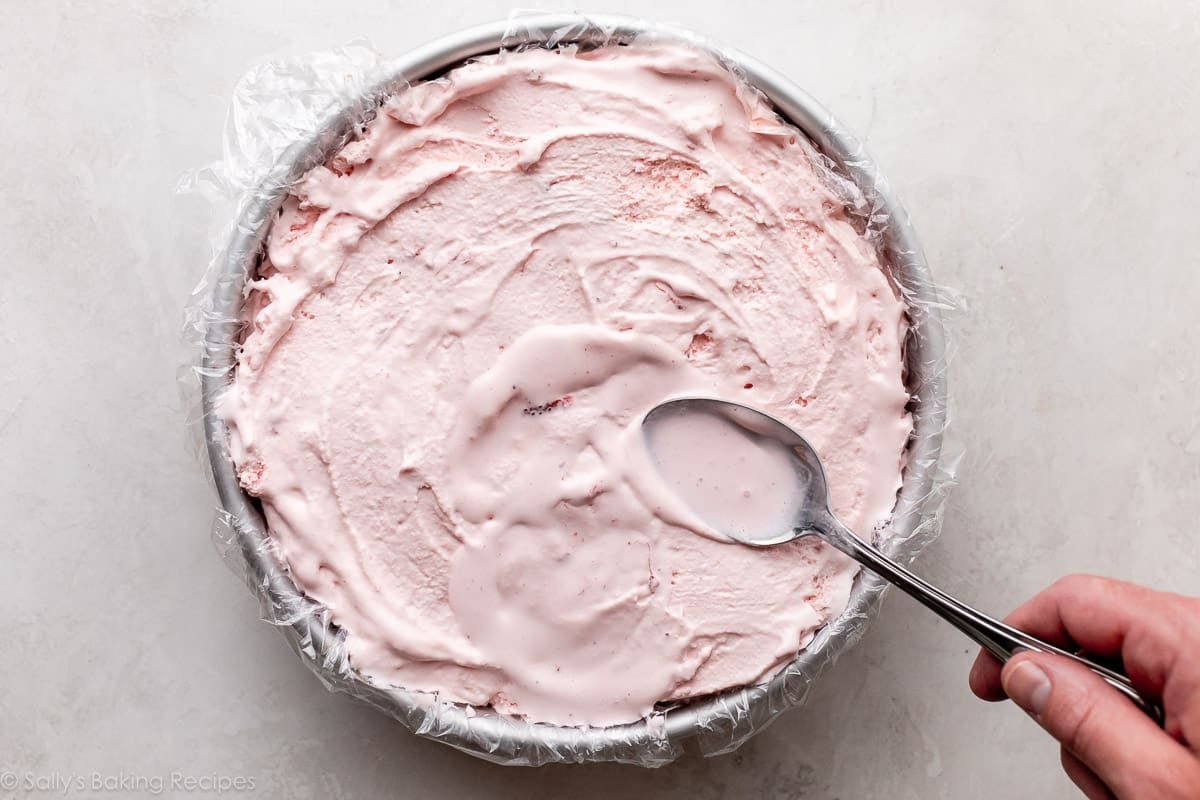 spreading strawberry ice cream in springform pan.