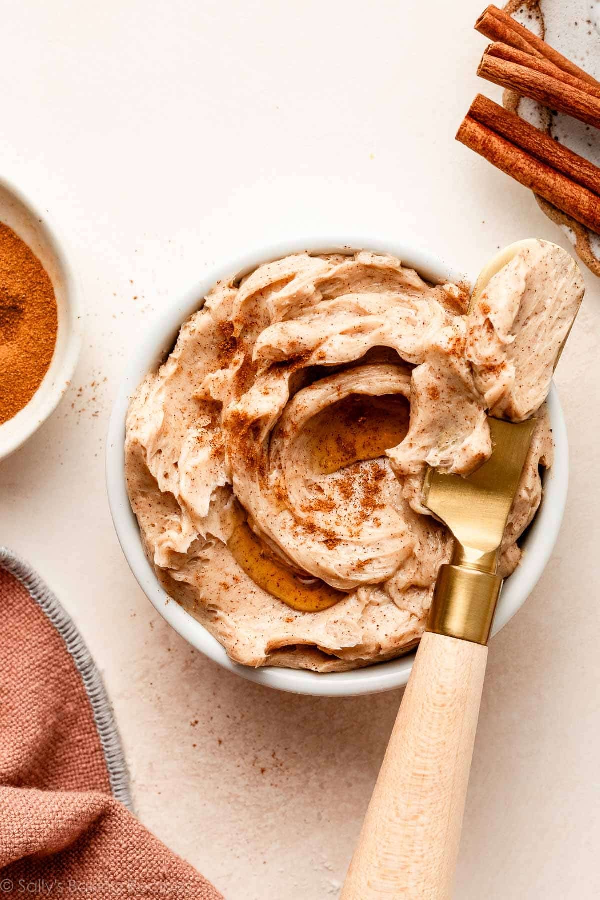 cinnamon butter in white dish with gold butter knife.