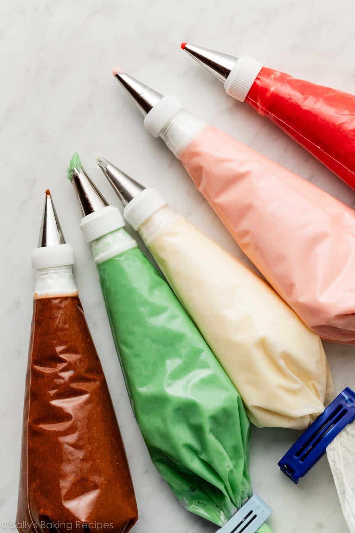 piping bags with piping tips and couplers filled with colored frosting.