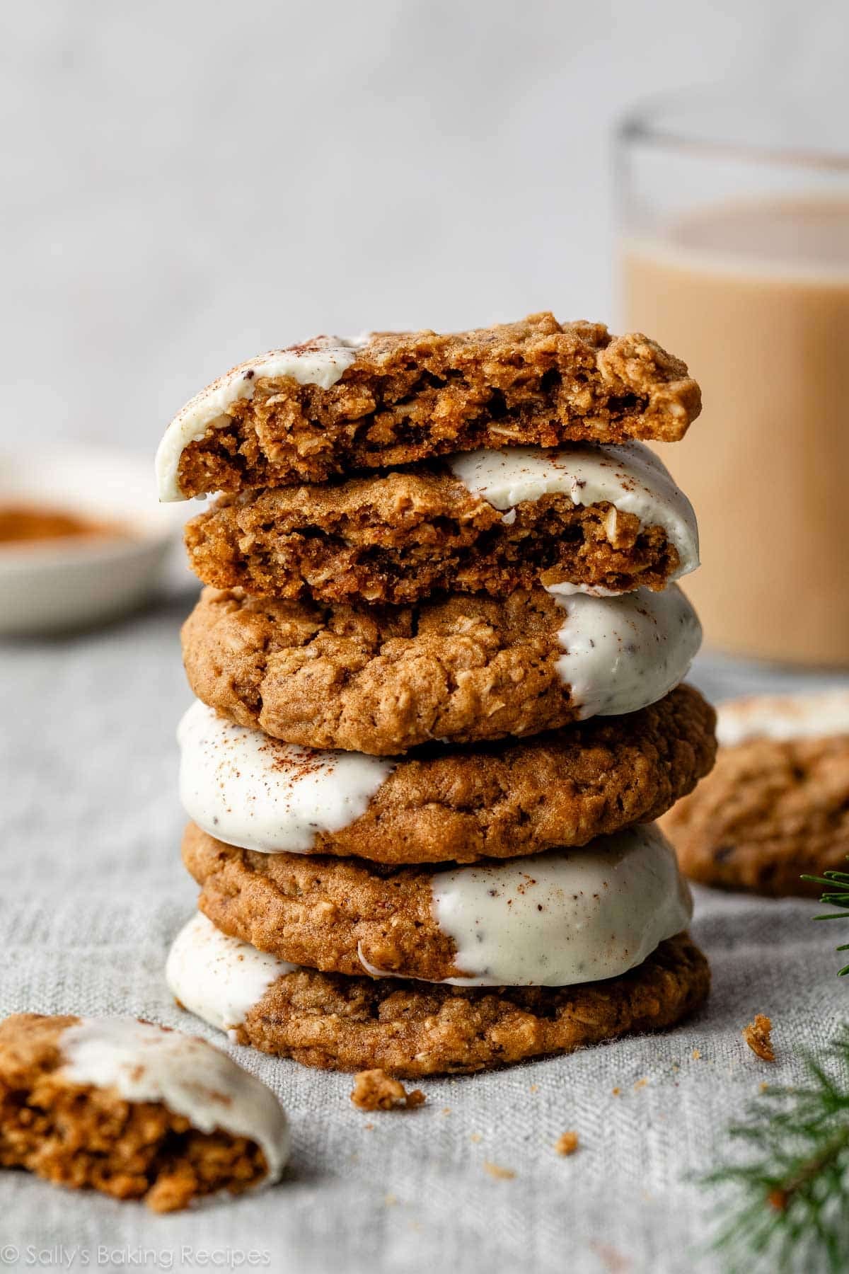 stack of gingerbread oatmeal latte cookies with glass mug of coffee in the background.