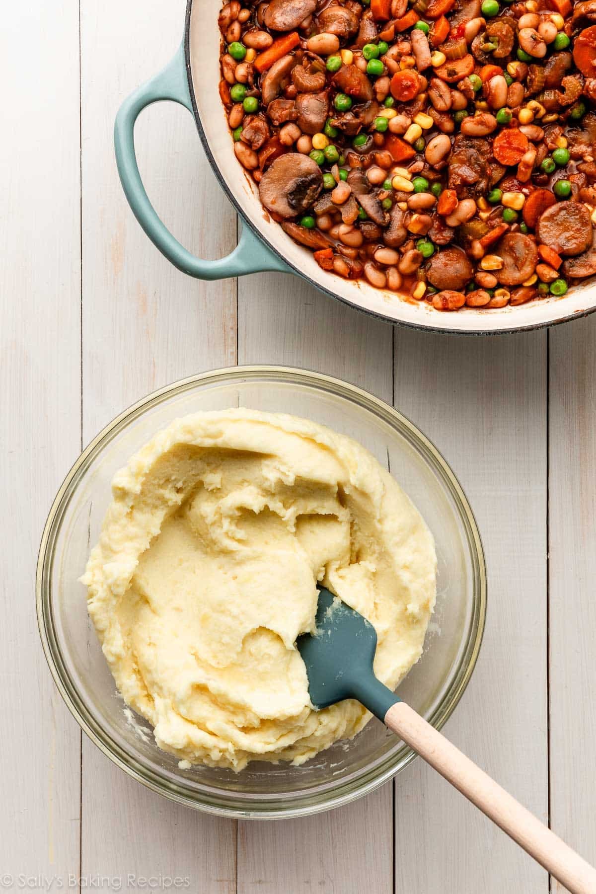 bowl of mashed potatoes and skillet of cooked down vegetables and herbs.