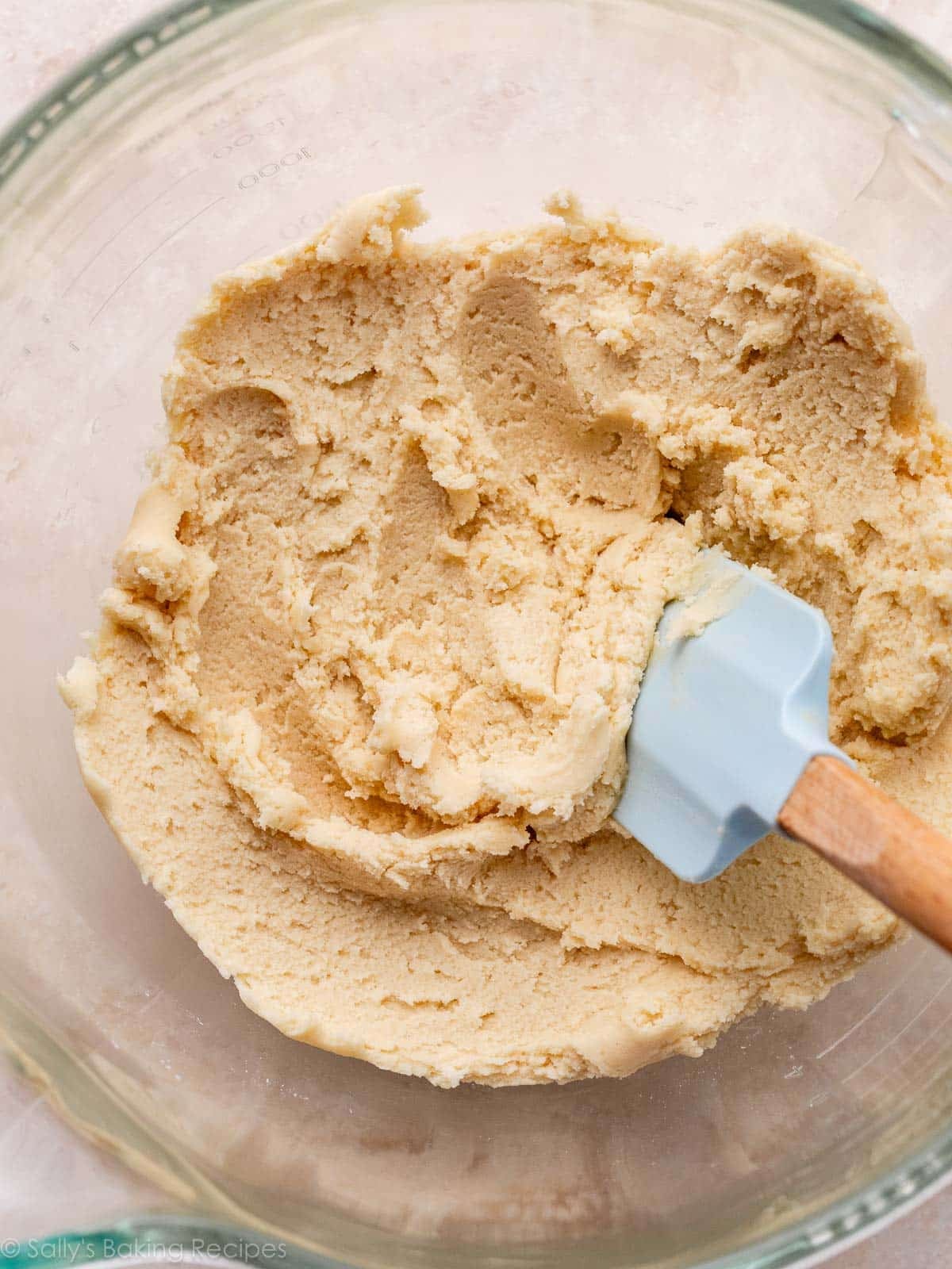vanilla peppermint cookie dough in glass bowl with light blue spatula.