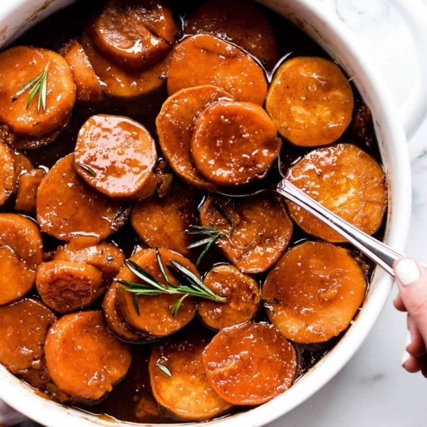 candied sweet potatoes Thanksgiving side dish in round white baking dish.
