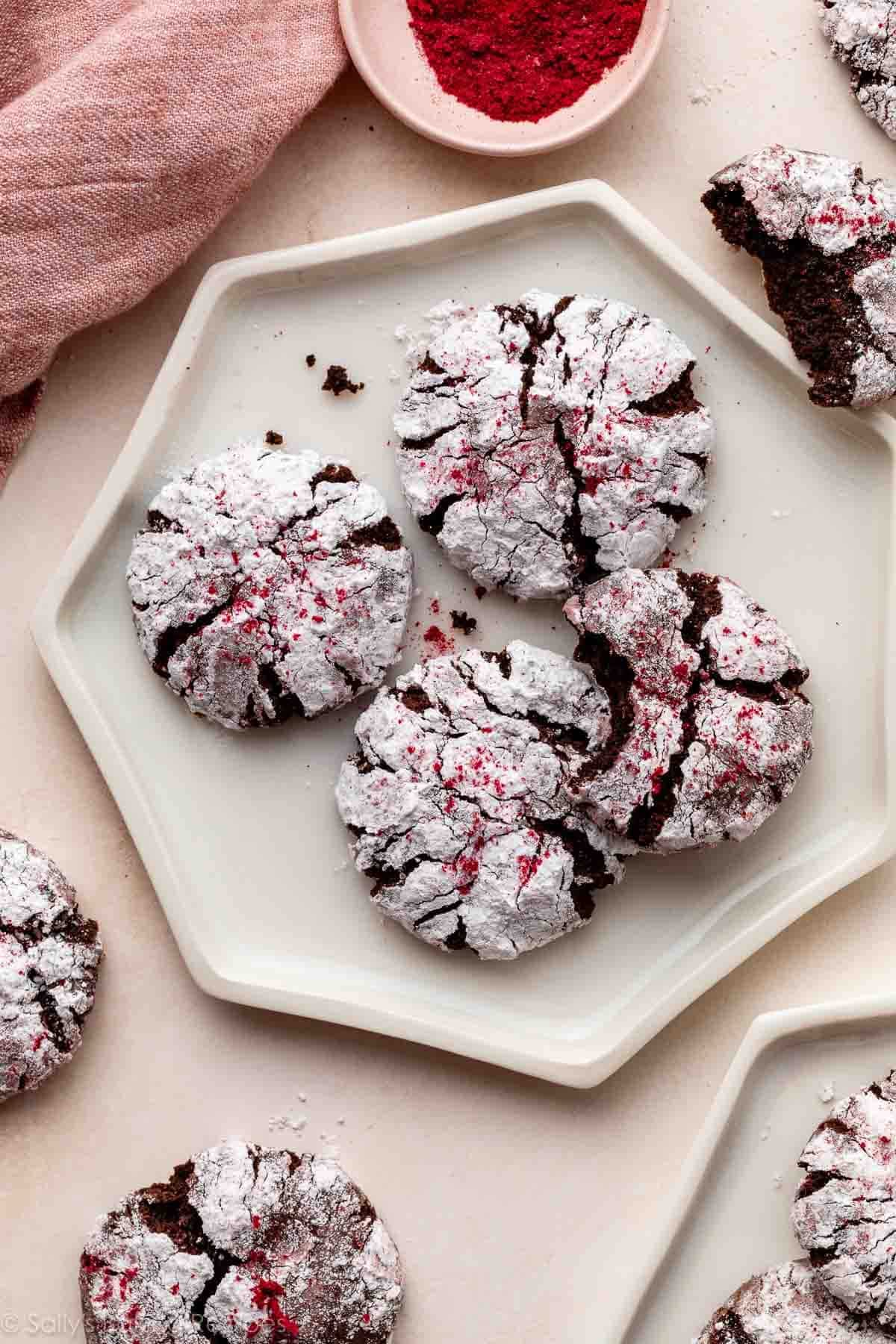 chocolate raspberry crinkle cookies on white hexagon-shaped plate.