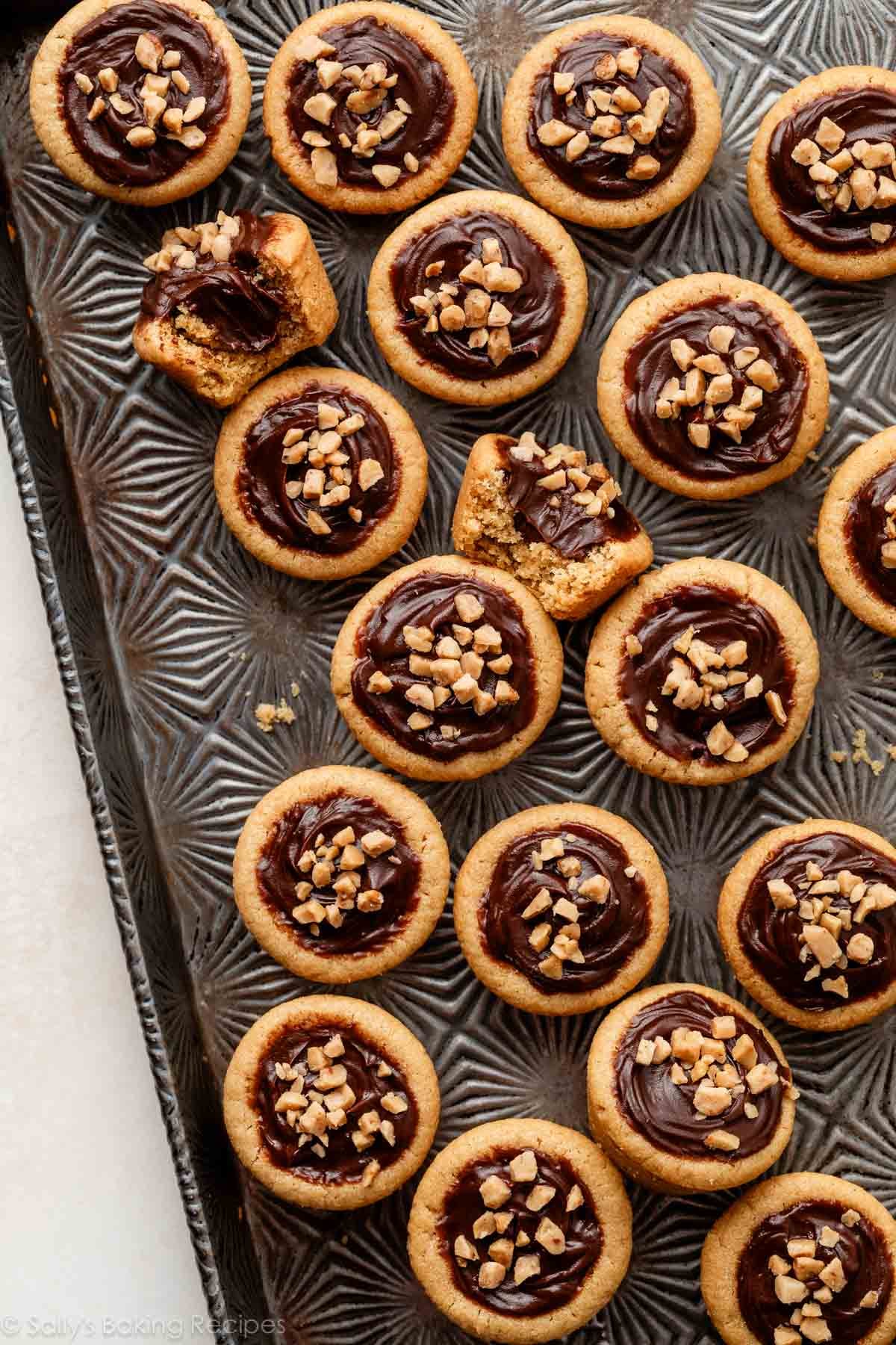 peanut butter cookie cups with fudge filling on designed baking sheet.