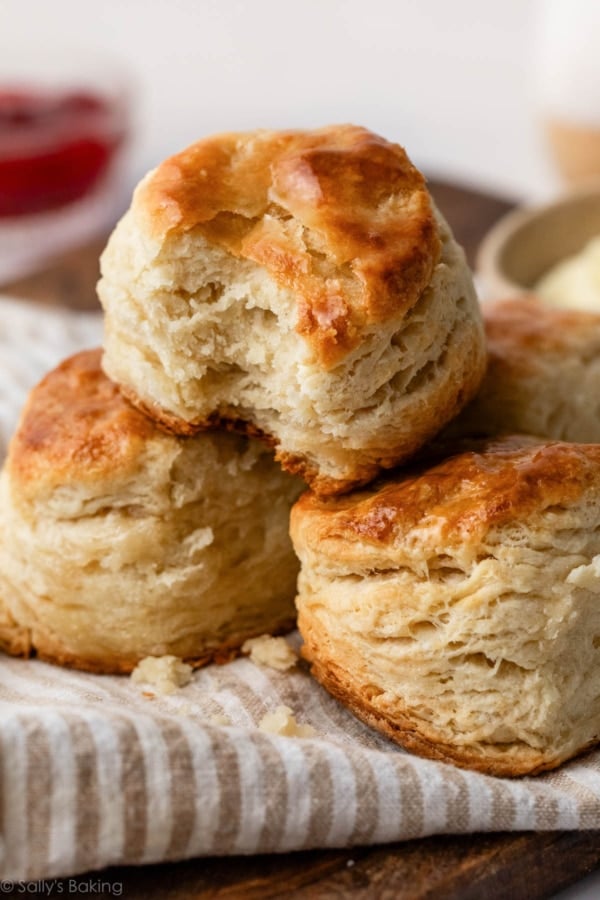 3 homemade biscuits in a pile on striped linen.