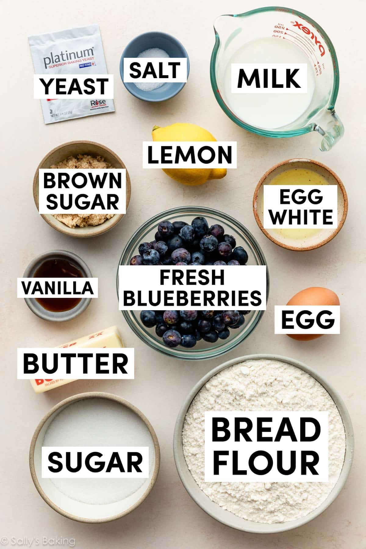 ingredients in bowls including egg white, milk, bread flour, sugar, brown sugar, vanilla, and salt.