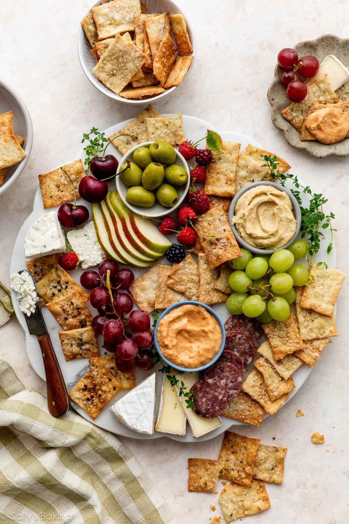 charcuterie platter with homemade crackers, cheese, salami, grapes, and hummus.