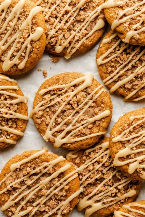 pumpkin crumb cake cookies with maple icing on parchment paper.