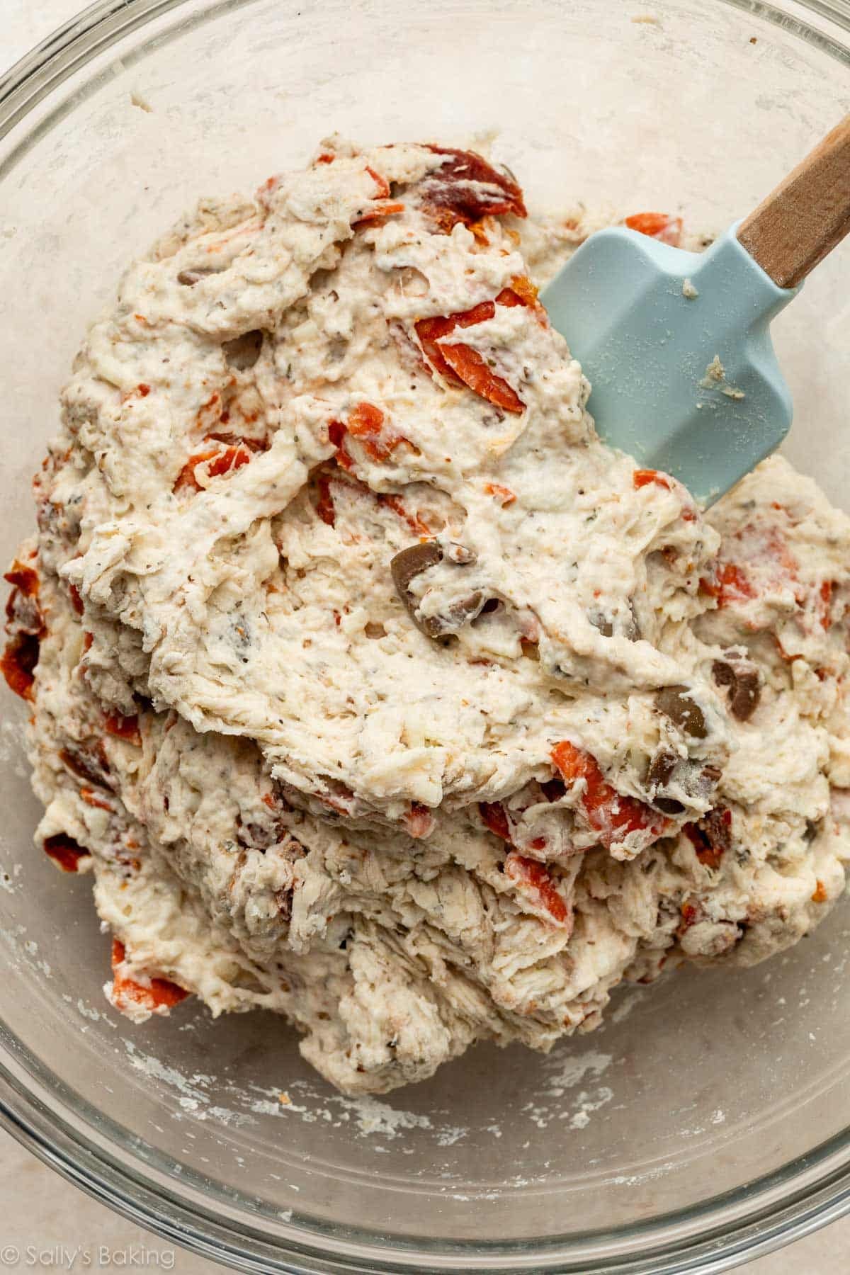 spatula mixing pepperoni pizza dough.