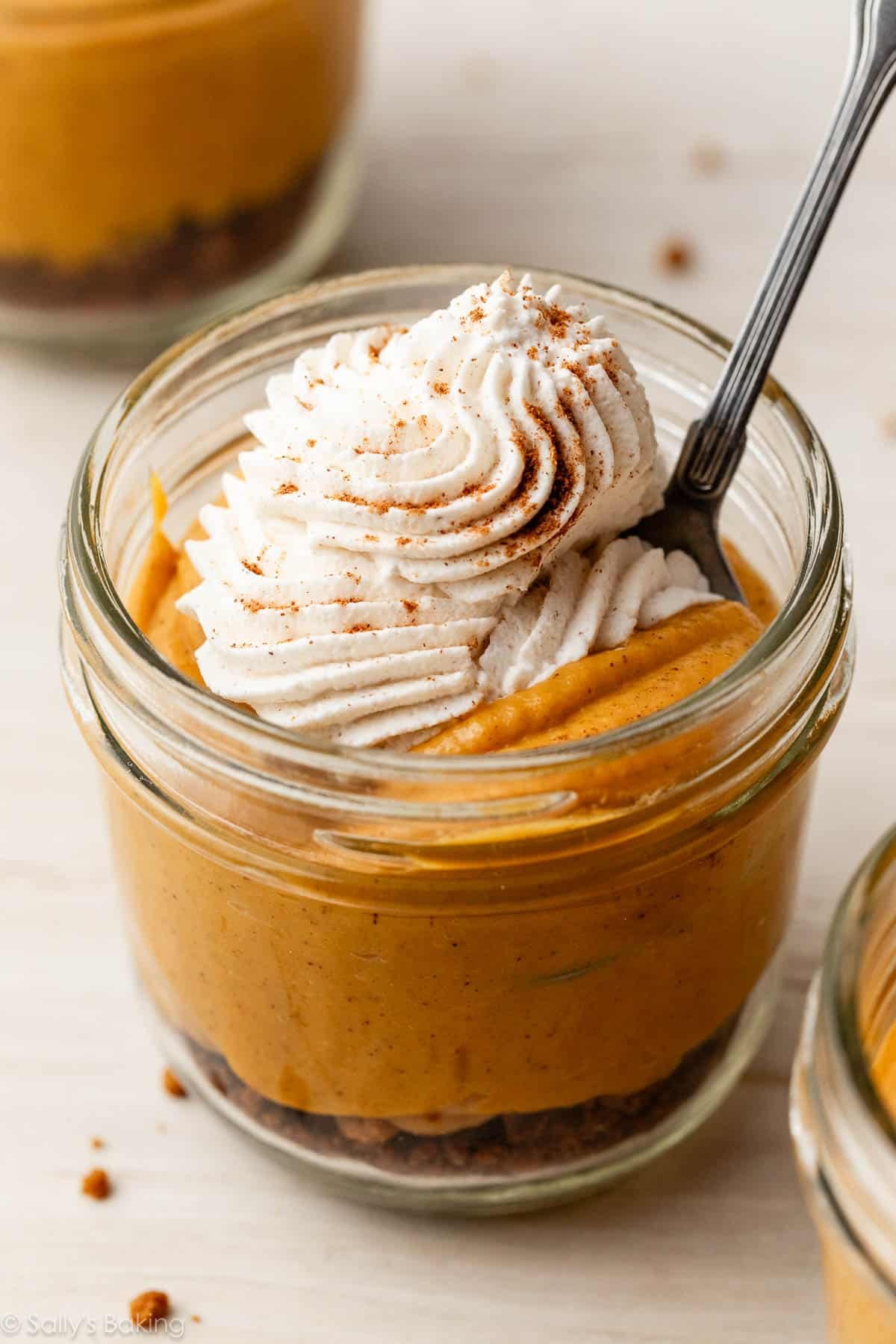 pumpkin pie in a jar with whipped cream on top.