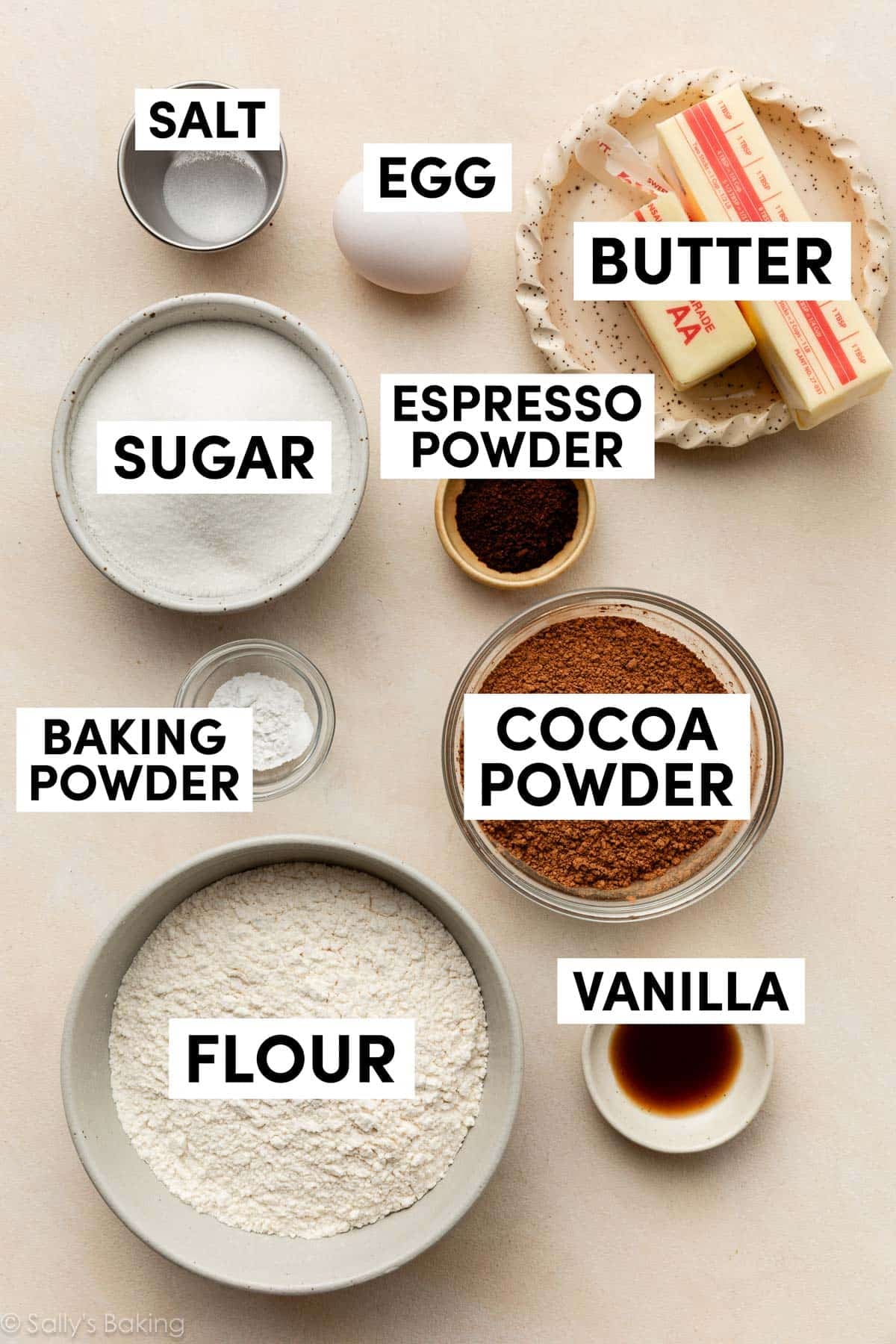 ingredients in bowls including flour, cocoa powder, butter, sugar, and egg.