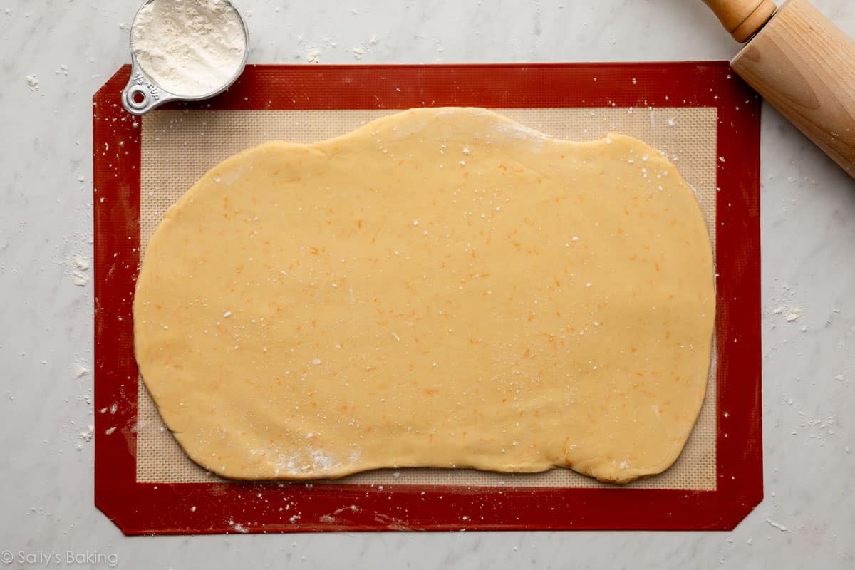 cookie dough rolled out on silicone baking mat.