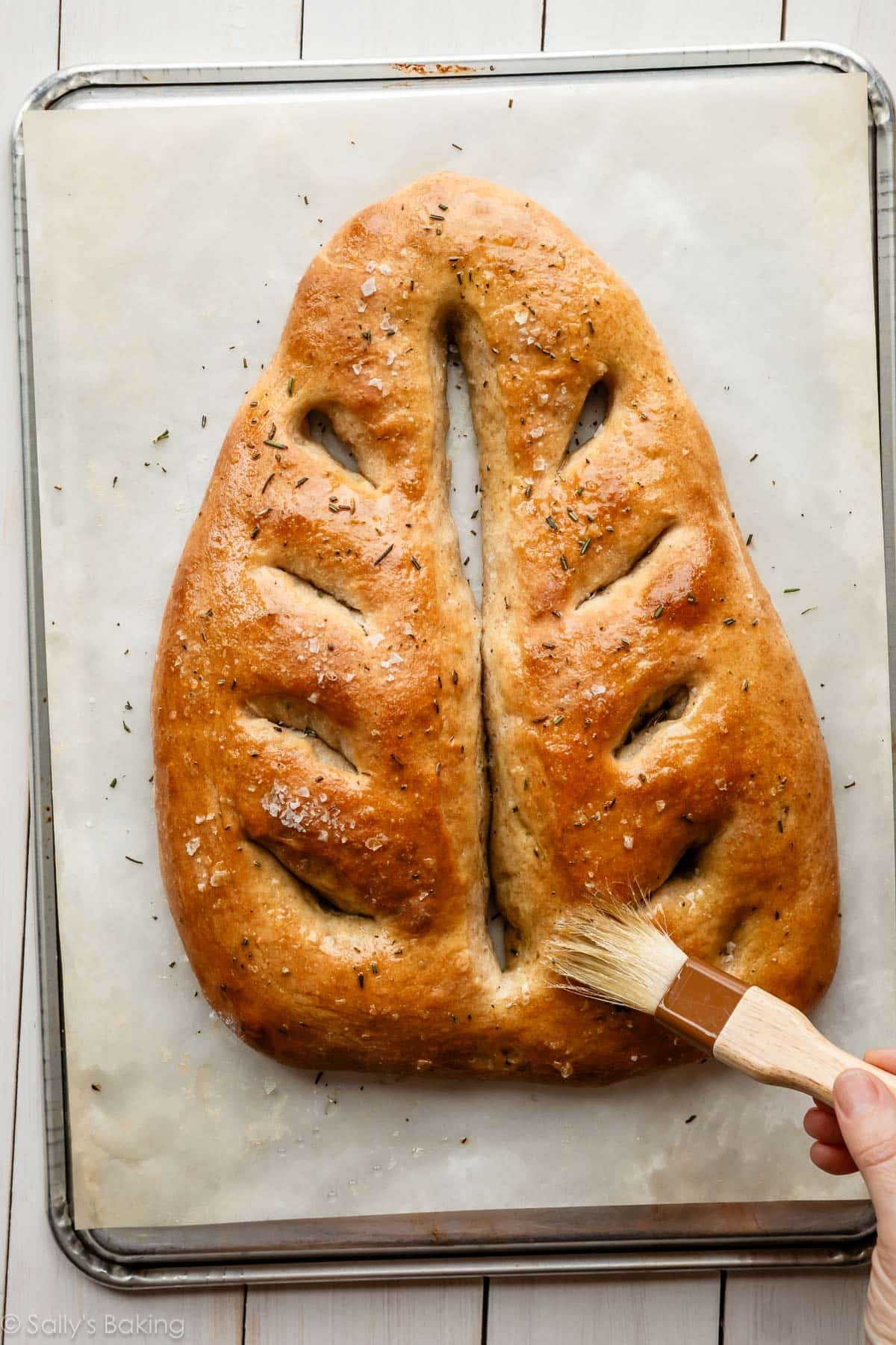french flatbread being brushed with olive oil.