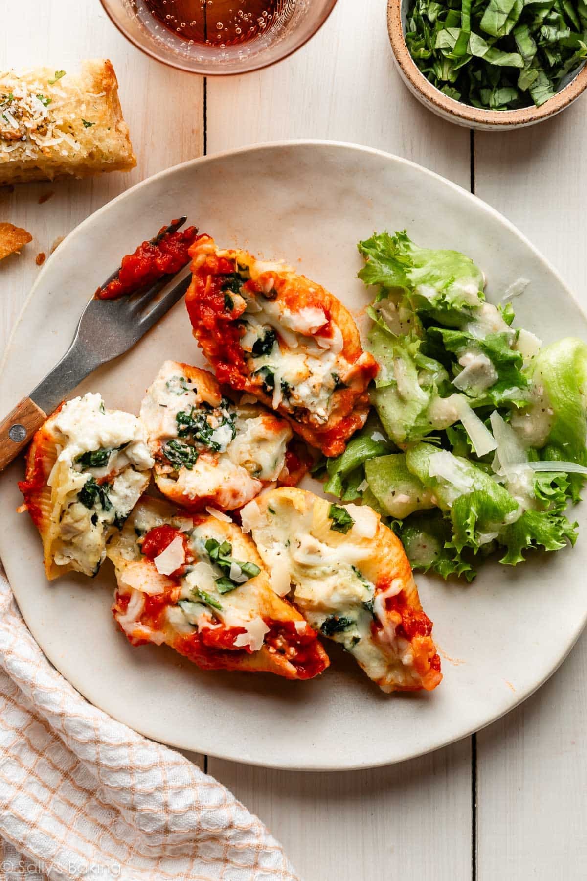 stuffed shells on plate with salad.