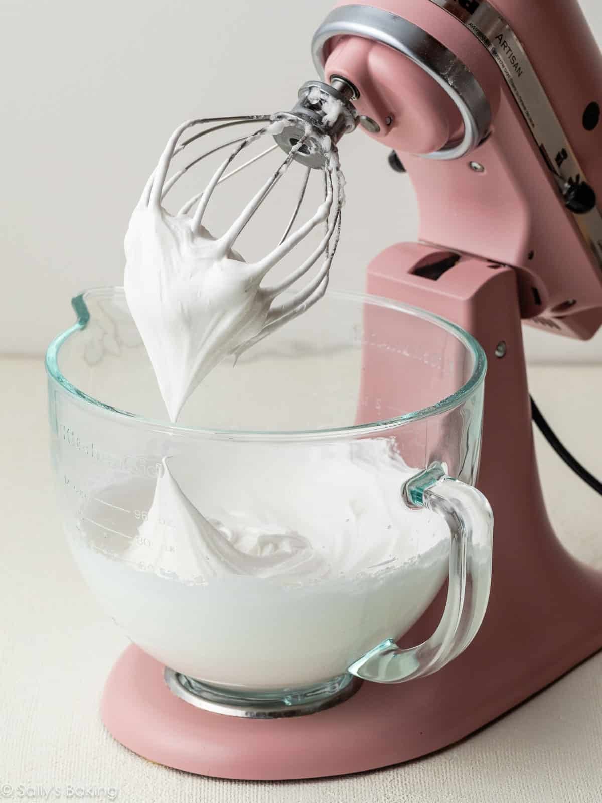 egg whites whipped into stiff peaks in pink stand mixer.