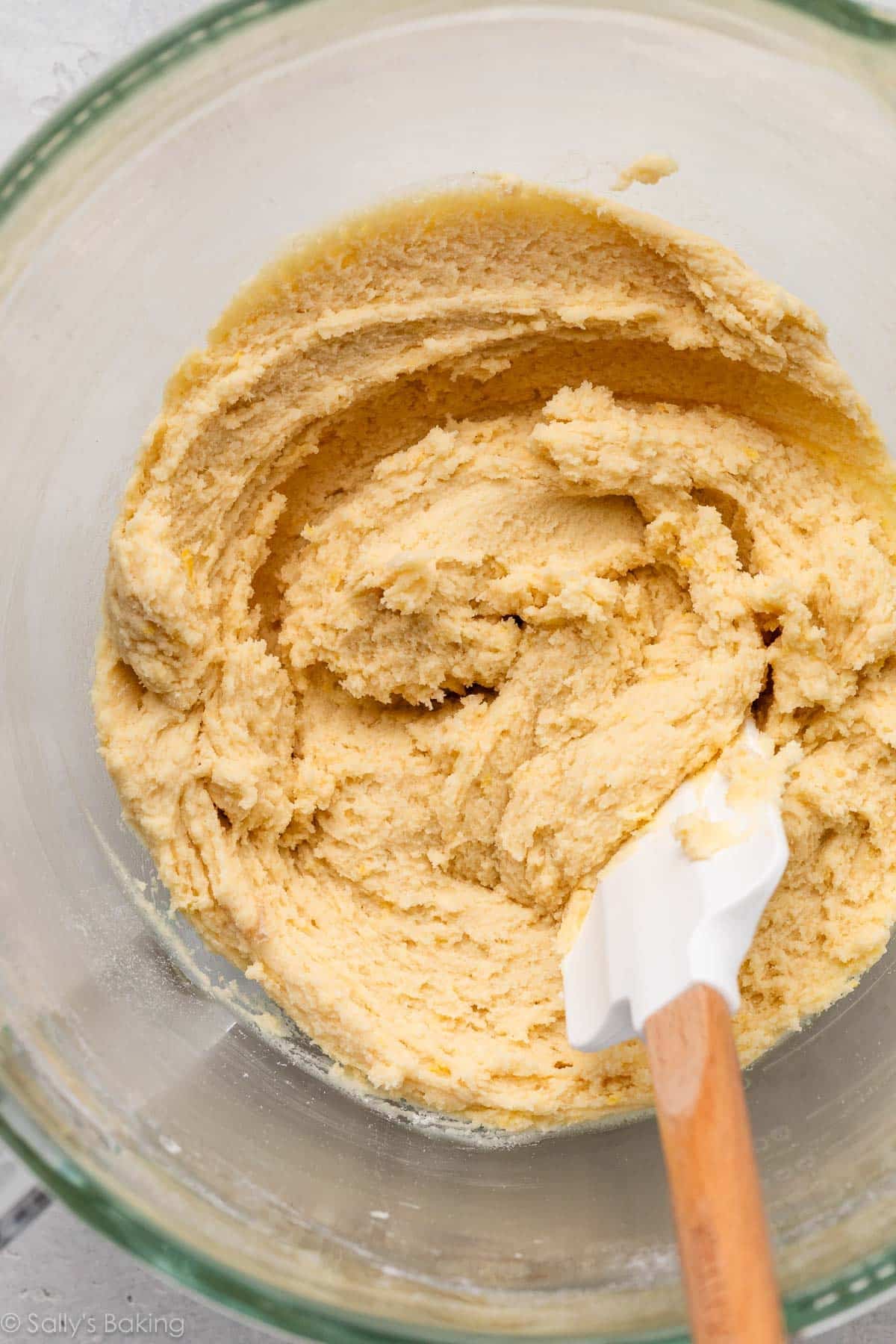 cookie dough in glass bowl with white spatula.