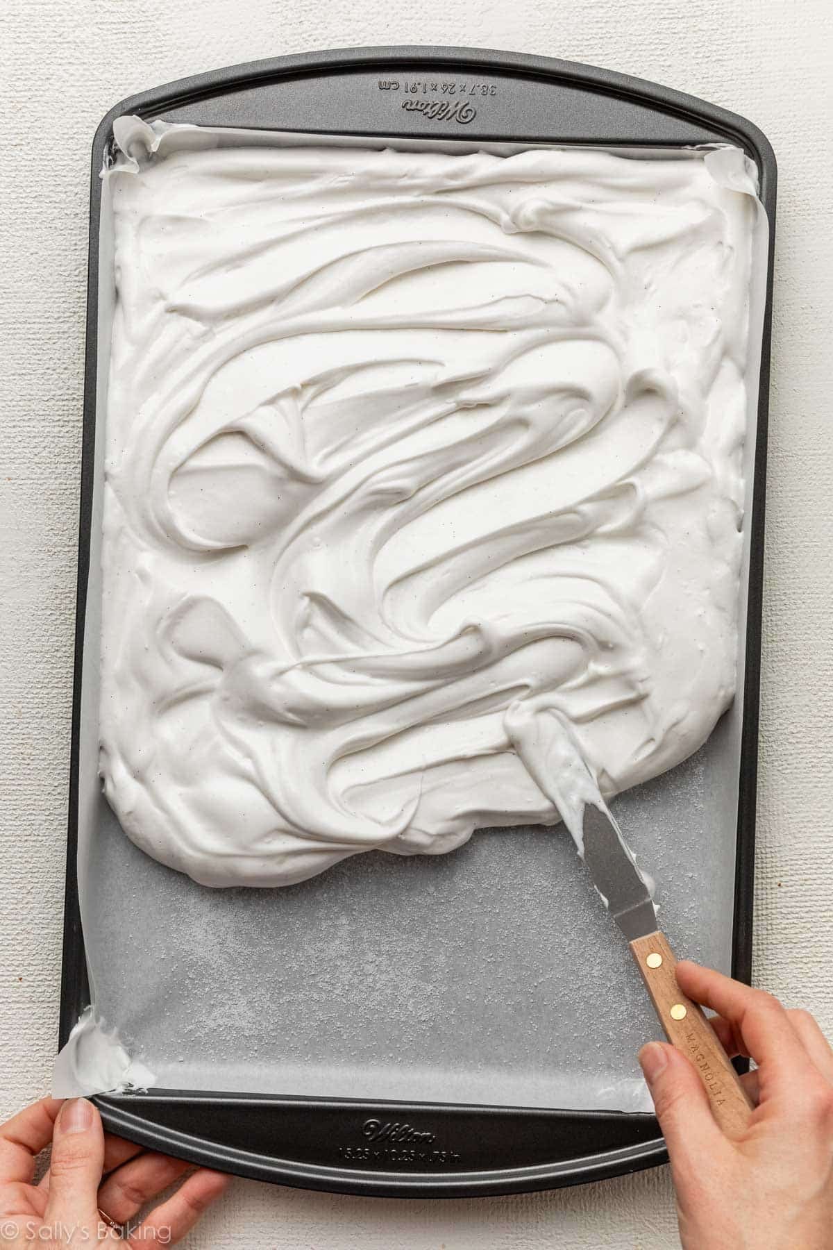 spreading meringue mixture on lined pan.